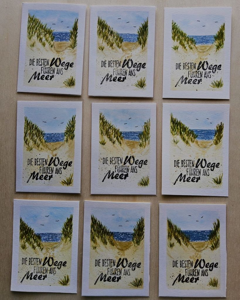 Serie Wege ans Meer: neun ATCs mit gemalten Dünenwegen, Dünengras und Blick aufs blaue Meer, darunter der Schriftzug „Die besten Wege führen ans Meer“